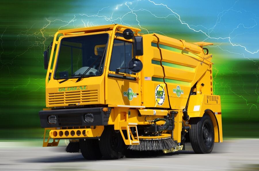 Yellow Global M3 street sweeper with green stripes against a green lightning background